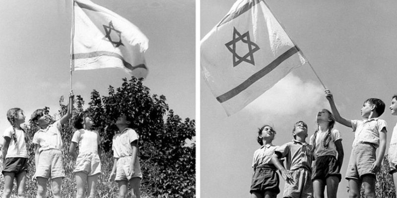 ילדי קיבוץ נצר סרני עם דגל ישראל ביום העצמאות, ישראל 1950 בקירוב. צילום לני זוננפלד המרכז לתיעוד חזותי עש אוסטר, אוסף זוננפלד, אנו מוזיאון העם היהודי
